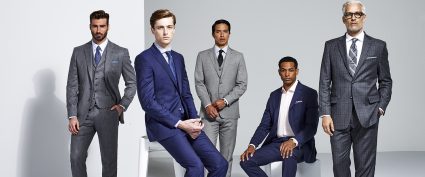 5 men wearing suits ranging from different shades of grey to different shades of blue