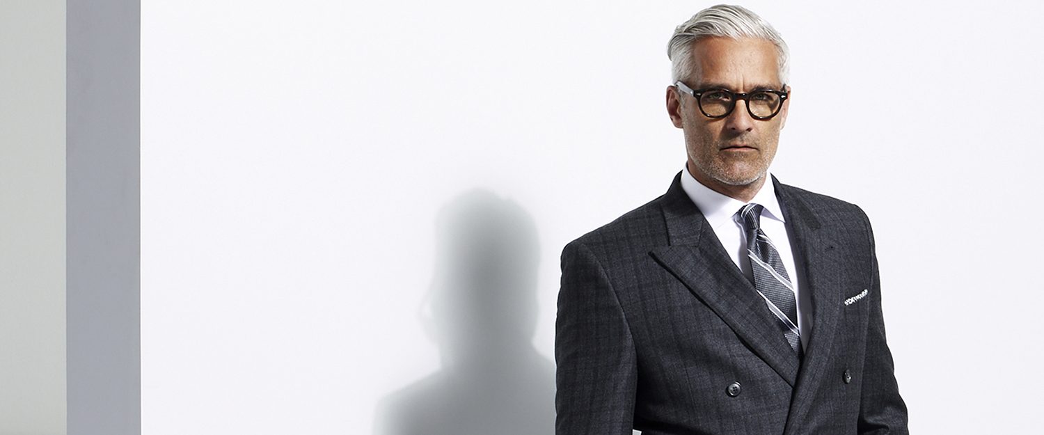 man with grey hair wearing a grey plaid suit