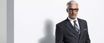 man with grey hair wearing a grey plaid suit